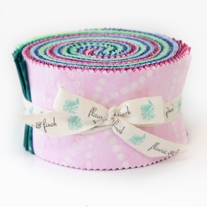 May include: A roll of pink and green fabric with white polka dots. The fabric is tied with a white ribbon with the text "flauric & finch" printed on it.