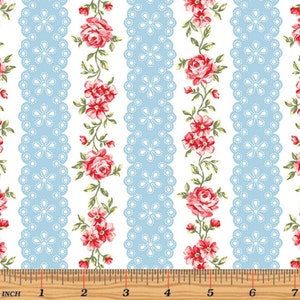 May include: White fabric with a repeating pattern of blue lace stripes and red floral vines. The fabric is measured with a ruler in inches.