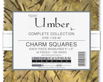 May include: A fabric charm square pack called "Umber" by Robert Kaufman Fabrics. The pack contains 42 squares, each measuring 5 inches by 5 inches, for a total of 0.756 yards of fabric. The fabric is a brown and yellow batik with a pattern of abstract lines and shapes.