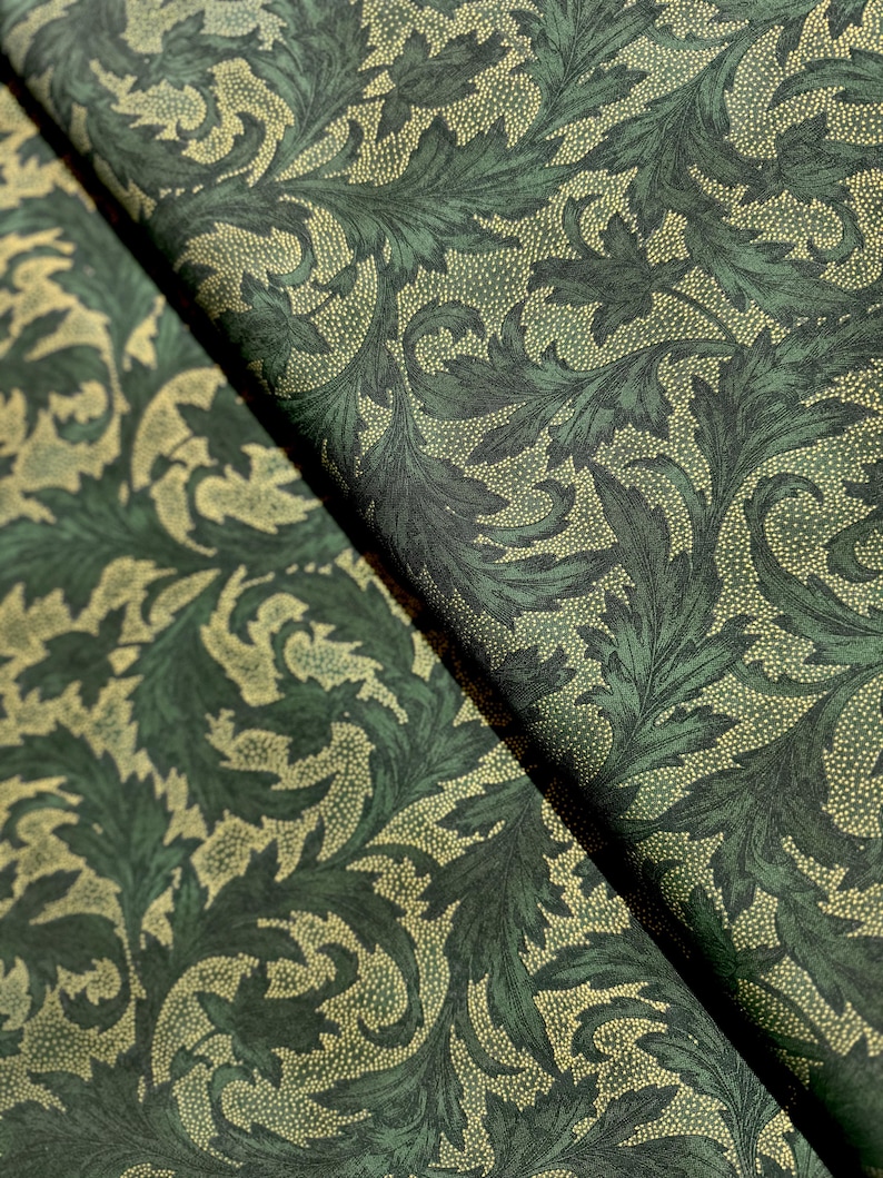 May include: Green fabric with a repeating pattern of stylized leaves and dots. The leaves are a dark green and the dots are a lighter green.