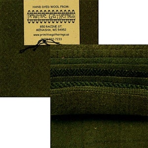 Op de afbeelding: Handgekleurd wollen stof in verschillende tinten groen. De stof is geweven met verschillende texturen en patronen. Het label vermeldt "Hand Dyed Wool From: Primitive Gatherings 850 Racine St. Menasha, WI 54952 www.primitivegatherings.us (920)-722-7233"