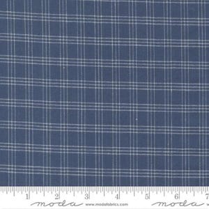 May include: Close-up of a blue fabric with a white plaid pattern. The fabric has a ruler along the bottom edge, with the word "moda" printed on it. The fabric is suitable for quilting and sewing projects.