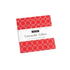 May include: Red fabric square with a white polka dot pattern. The fabric is labeled "Coriander Colors by Corey Yoder of Coriander Quilts".