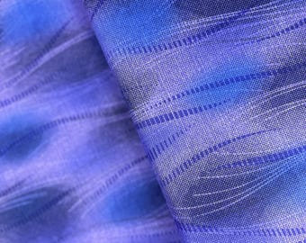Puede incluir: Primer plano de una tela azul y morada con un patrón tejido. La tela tiene un brillo sutil y una textura suave y fluida.