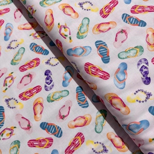 May include: White fabric with a repeating pattern of colorful flip flops. The flip flops are in various shades of blue, green, pink, and yellow.