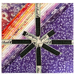May include: A bundle of 24 fat quarters of purple, pink, orange, and yellow batik fabric with a floral pattern. The fabric is tied together with a ribbon that says "Island Batik".