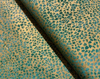 May include: Close-up of a folded fabric with a mosaic pattern. The fabric features a teal background with a gold, irregular, geometric design. The fabric has a soft, velvety texture and a slight sheen, creating a luxurious appearance.