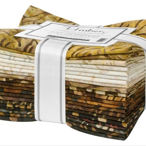 Könnte beinhalten: Ein Stapel von 20 Stoffquadraten in verschiedenen Brauntönen, Beige und Creme. Die Stoffquadrate sind mit einem weißen Band und einem Etikett mit der Aufschrift "Umber" und "Fat Quarters" zusammengebunden.