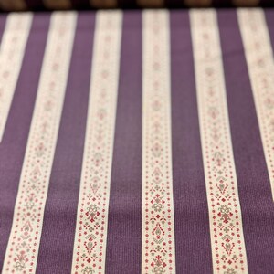May include: Purple and white striped fabric with a small floral pattern. The fabric has a subtle texture.