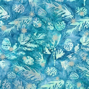 Puede incluir: Una tela con un fondo de acuarela azul y verde azulado con un patrón repetitivo de ramas de pino y piñas de color azul claro. El diseño está acentuado con pequeños copos de nieve de purpurina plateada dispersos por toda la superficie.