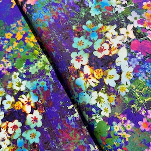 May include: A purple fabric with a floral print featuring white, blue, and yellow flowers. The fabric has a textured, almost watercolor-like appearance.