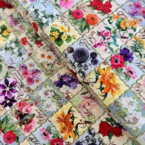 May include: A fabric with a repeating pattern of colorful flowers and botanical illustrations in a grid. Each square features a different flower with its name written in cursive script. The background is a light cream color with a subtle blue and green checkered pattern.