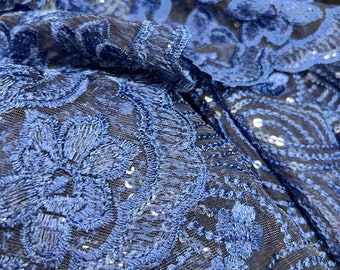 May include: Blue sequined fabric with a floral pattern. The fabric is sheer and has a delicate texture.