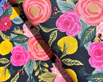 May include: A dark blue fabric with a floral pattern featuring pink, yellow, and green flowers. The fabric is folded in half, showing the pattern on both sides.