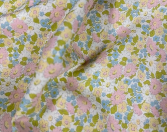 May include: White fabric with a small floral print in pink, blue and yellow.