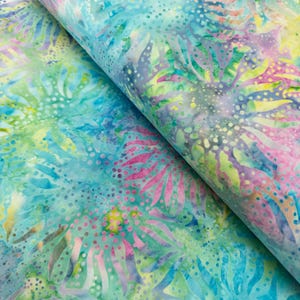 May include: Close-up of a fabric with a vibrant floral pattern. The design features a mix of colours, including turquoise, pink, yellow, and green. The fabric appears to be folded, revealing the pattern's repeating nature. The overall aesthetic is bright and colourful.