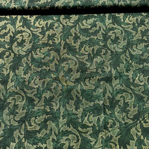 May include: Green fabric with a gold leaf pattern. The fabric has a subtle shimmer.