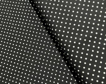 May include: Black fabric with a white polka dot pattern.