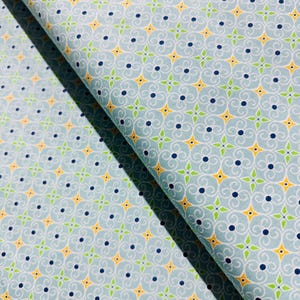 May include: A blue fabric with a repeating pattern of yellow, green, and blue swirls. The fabric has a subtle sheen and a soft texture.
