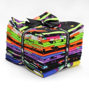 May include: A stack of colorful fabric squares tied with a black ribbon and bow. The fabric features Halloween-themed patterns in black, orange, green, purple, and blue. The ribbon has the text "#quiltwithlove" and "RJR Fabrics".