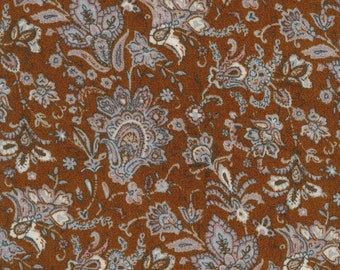 May include: Brown fabric with a paisley pattern in shades of blue, pink, and white. The fabric has a textured surface.