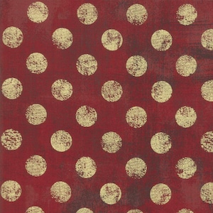 Peut inclure: Tissu rouge avec un motif répétitif de pois dorés.