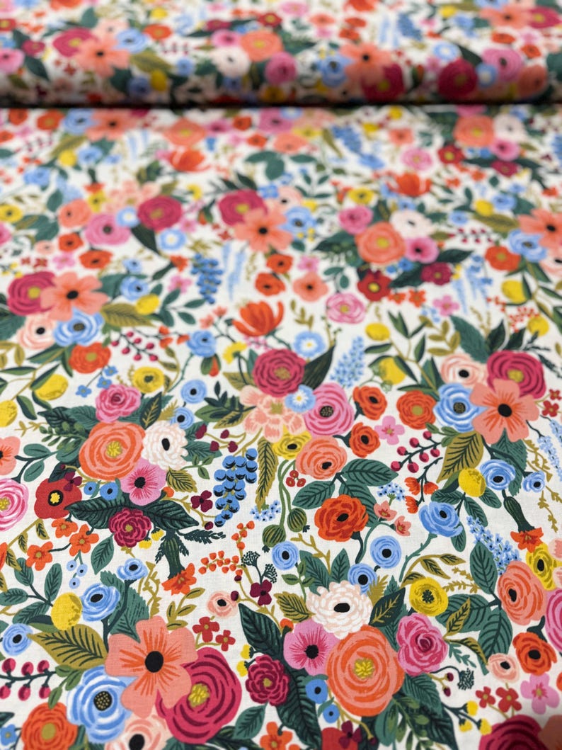 May include: White fabric with a floral pattern featuring a variety of colorful flowers, including pink, red, orange, yellow, blue, and green.