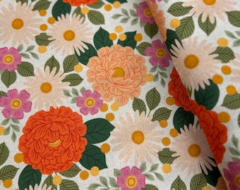 May include: A white fabric with a floral pattern featuring orange, pink, and yellow flowers. The fabric has a subtle texture and a vintage aesthetic.