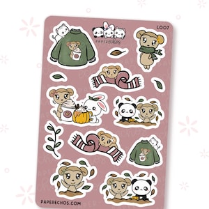 May include: A sticker sheet with various cartoon illustrations. The designs include monkeys, pandas, cats, and a bunny, along with coffee cups, scarves, and leaves. The color palette features shades of brown, green, and pink.
