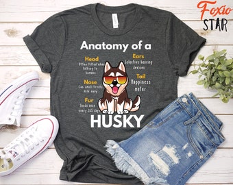 May include: A dark gray t-shirt with a cartoon husky dog and the text "Anatomy of a Husky". The text describes the dog's features, including its head, ears, nose, tail, and fur.