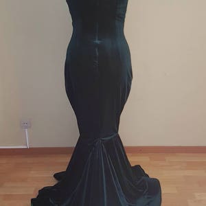 May include: A dark green velvet off-the-shoulder gown with a fitted bodice and a flowing skirt.