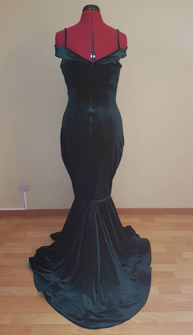 May include: A dark green velvet off-the-shoulder gown with a fitted bodice and a flowing skirt.