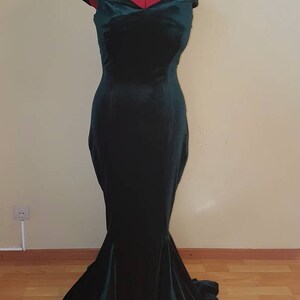 May include: A dark green velvet off-the-shoulder gown with a fitted bodice and a flowing mermaid skirt.