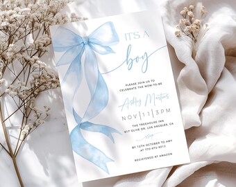 May include: A baby shower invitation with a watercolor blue bow and the words "IT'S A boy". The invitation includes the name Ashley Martins, the date November 11th, and the time 3 PM. The Treehouse Inn address is also listed.