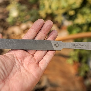 May include: A silver metal file with a black handle. The file is labeled "Helko Werk Germany".
