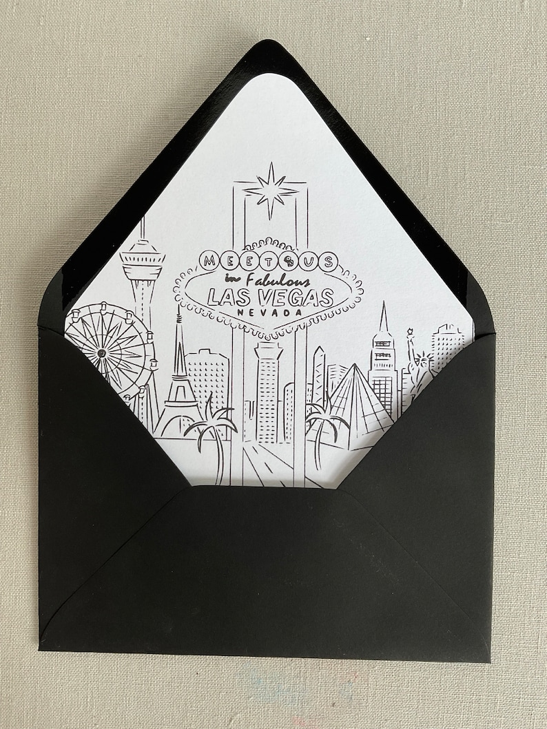 May include: A black envelope with a white card inside. The card features a black and white illustration of the Las Vegas skyline with the text "Meet Us in Fabulous Las Vegas Nevada".