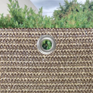 May include: Close-up of a brown and beige shade cloth with a silver grommet.