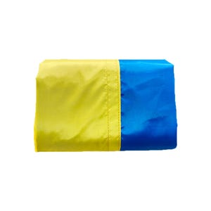 May include: A folded, rectangular tote bag with a yellow and blue color scheme. The bag is divided vertically, with a yellow section on the left and a blue section on the right. The bag appears to be made of a lightweight, possibly nylon, material.