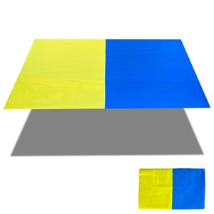 May include: A yellow and blue rectangular fabric. The fabric is folded in half, with the yellow side on top and the blue side on the bottom. The fabric is lying flat on a white surface.