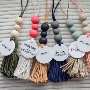 May include: Six door hangers with different messages and colors. The messages are "occupied", "meeting in progress", "open", "do not disturb", "private", and "welcome". The colors are green, white, tan, blue, beige, and pink.