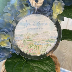 May include: A clear acrylic ornament with a watercolor illustration of a garden scene and the text "Jon & Kristen September 1, 2018".