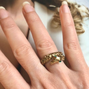 Peut inclure: Une bague en or façonnée comme un serpent avec des yeux en pierres précieuses vertes.