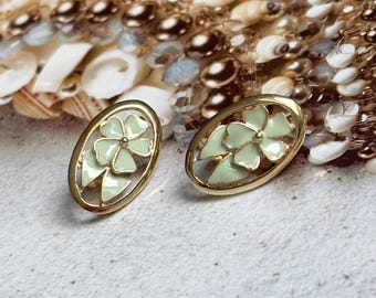 Puede incluir: Un par de pendientes ovalados de oro con un diseño de flor de esmalte verde claro.