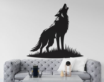 May include: A black silhouette of a wolf howling at the moon, set against a white wall. The wolf is standing on a grassy patch. The image is displayed above a gray sofa with a white throw pillow.