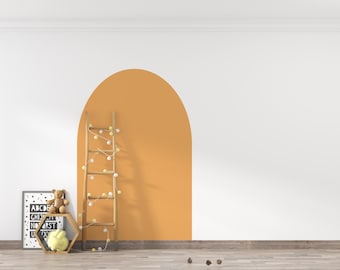 Puede incluir: Una habitación con una pared blanca y un arco naranja. Una escalera de madera con luces de cadena se apoya contra el arco. Una impresión del alfabeto enmarcada y una estantería con un oso de peluche y un conejito amarillo están a la izquierda.