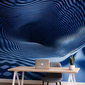 May include: A modern office space featuring a blue abstract wallpaper with a wave pattern. A wooden desk holds a laptop, a potted plant, and a gray chair. The room has a minimalist design with a focus on the blue color scheme.