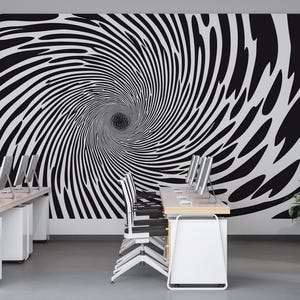 Peut inclure: Un espace de bureau avec une murale en spirale noire et blanche. La pièce comprend plusieurs bureaux avec des écrans d'ordinateur, des chaises blanches et une plante en pot. Le design crée une illusion d'optique.