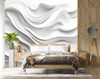 May include: A modern bedroom featuring a large white abstract wall mural with flowing wave-like patterns. The room includes a wooden bed frame, nightstands, and a decorative floor lamp. A green plant in a glass vase adds a touch of color.