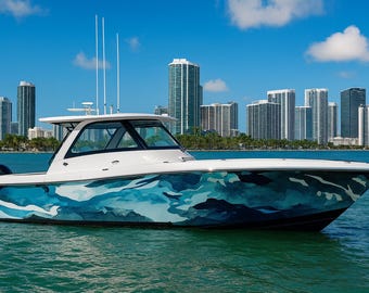 May include: A white motorboat with a blue and teal camouflage pattern on the hull floats on the water. The boat has a white roof and a black motor. Tall buildings are in the background under a blue sky.