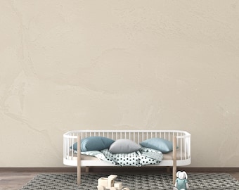 May include: A white crib with a rounded design, featuring blue and gray pillows and a patterned blanket. A gray rug and wooden toys are in front of the crib. The wall is a light beige color.